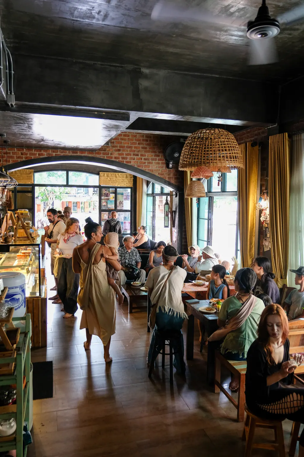 Inside Barbari Bakery — long table, brick walls, woven lamps